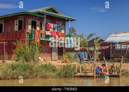 Mutter und Tochter waschen Kleidung vor ihrem Haus, Inle Lake Myanmar Stockfoto