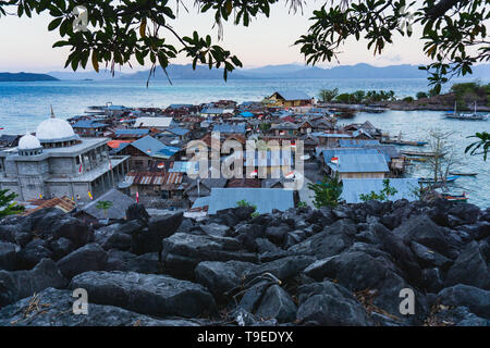 Eine Moschee auf einer kleinen Insel im Norden der Insel Flores Indonesien mit Blättern als Vordergrund und durch die blauen Meere umgeben und es wird von Doze bewohnt Stockfoto