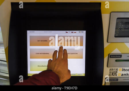 Prag, Tschechische Republik - 18. Mai 2019: Bitcoin ATM Maschine für den Kauf und Verkauf von cryptocurrency. Männliche verkauft Bitcoins von ATM, Prag, Tschechische Republik. Stockfoto