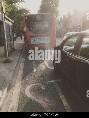 Ein Londoner Bus, scheint zu sein, eine große Wolke von Diesel fossilen Brennstoffe Abgase und Verschmutzung an einem sonnigen Tag wie Er beschleunigt weg von einer Bushaltestelle. (108) Stockfoto