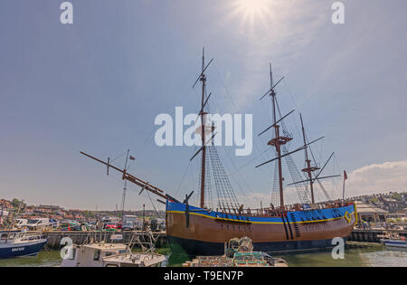 Eine Replik von HMS ENDEAVOUR günstig in Whitby Harbour. Die Masten bis in den blauen Himmel und Hummer Töpfe stehen im Vordergrund. Stockfoto