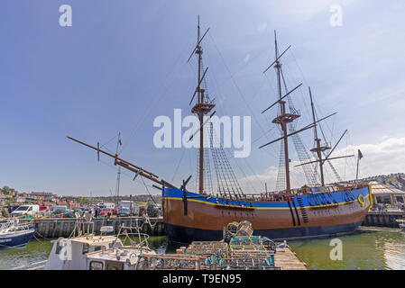 Eine Replik von HMS ENDEAVOUR günstig in Whitby Harbour. Die Masten bis in einen blauen Himmel und es gibt Hummer Töpfe in den Vordergrund. Stockfoto