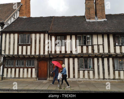 Die Besucher gehen Vergangenheit Tudor Häuser an der Guildhall in Stratford-upon-Avon. Warwickshire. Mai 2019. Stockfoto