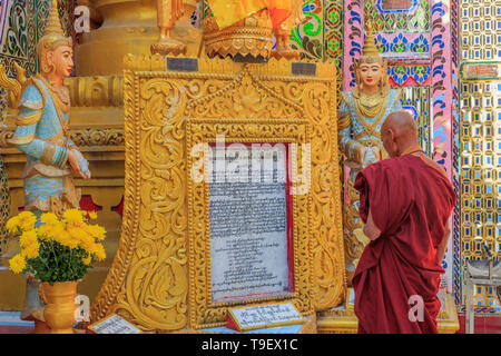 Mönch lesen eine Inschrift in der Su Taung Pyae Pagode in Mandalay Stockfoto