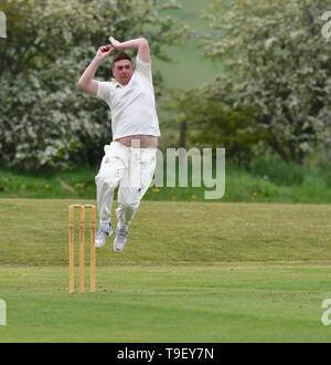 Ein Bowler in Aktion während er Derbyshire und Cheshire Cricket Liga Match zwischen Birch Vale und Thornsett und Hazel Grove. Stockfoto