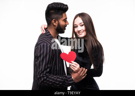 Zwei junge Menschen in Freizeitkleidung Umarmen und Halten Herz auf weißem Hintergrund Stockfoto