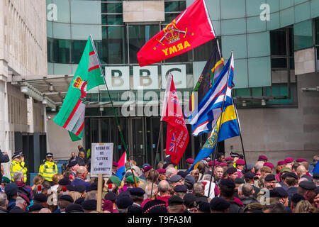 London, Großbritannien. 18. Mai 2019. Zuerst die Armee Veteranen, viele tragen Baskenmützen und Medaillen, waren hinter Barrieren in frong der BBC in ihrem Protest für ein Ende der Strafverfolgung von Soldaten für Tätigkeiten im Betrieb Banner, die Streitkräfte Betrieb während der Unruhen von 1969-2007 gehalten. Die Regierung hat verkündet, dass die Mitglieder der Streitkräfte sind von der Verfolgung für historische Straftaten geschützt, außer in Nordirland. . Peter Marshall / alamy Leben Nachrichten Stockfoto