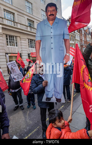 London, Großbritannien. 18. Mai 2019. Ein Mann hält eine große Zahl von Velupillai Prabhakaran (1954-2009) der Gründer und Führer der LTTE vor dem Marsch durch mehrere tausend Tamilen durch London auf Mullivaikkal Gedenktag in Erinnerung an die von Genozid Sri Lanka's Krieg gegen die Tamilen, die vor zehn Jahren endete getötet. Sie fordern eine politische Lösung, die Tamilen, die Kontrolle über ihre Heimat von Tamil Eelam, und für ein Ende des Verbots der Tamil Tigers. Öffentliche gedenken der vielen Tausend Krieg tot sind in Sri Lanka verboten. Peter Marshall / alamy Leben Nachrichten Stockfoto