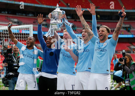 (190519) - LONDON, 19. Mai 2019 (Xinhua) - Manchester City Kyle Walker (1. R), John Steine (2. R), Kevin De Bruyne (C), Raheem Sterling (1. L) feiern mit der Trophäe, als sie nach dem Gewinn der englischen FA Cup Finale zwischen Manchester City und Watford im Wembley Stadion in London, Großbritannien am 18.Mai 2019 feiern. Manchester City gewann 6-0 und wurde der erste englische Männer Seite das Meisterstück des Gewinnens der Premier League, FA Cup und Carabao Cup in der gleichen Saison zu erreichen. (Xinhua / Han Yan) für die redaktionelle Verwendung. Nicht FÜR DEN VERKAUF FÜR MARKETING ODER WERBEKAMPAGNEN. Keine VERWENDUNG MIT NICHT AUTORISIERTEN Stockfoto