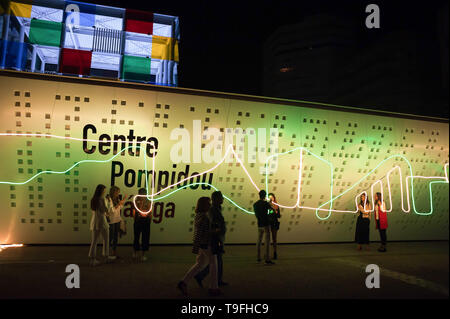 Malaga, Spanien. 19 Mai, 2019. Die Menschen sind vor der Fassade des Centre Pompidou Museum mit einer künstlerischen Beleuchtung und während der Nacht in Weiß" 2019 gesehen. Jeder Mai, Malaga feiert eine kulturelle Nacht mit mehr als 200 Aktivitäten in der Innenstadt wie Performances, Street Art, live Musik und kostenfreie Besuche in allen Museen. Credit: SOPA Images Limited/Alamy leben Nachrichten Stockfoto
