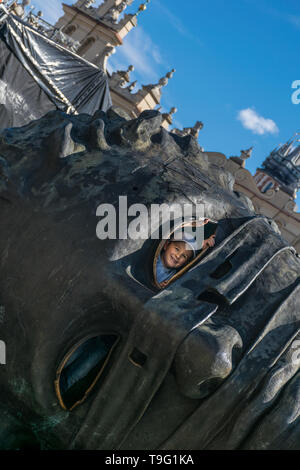 Krakau, Polen - 23. September 2018: lächelndes Kind durch das Loch im Kopf Skulptur Eros Bendato auf dem Marktplatz suchen, durch polnische gemacht Stockfoto