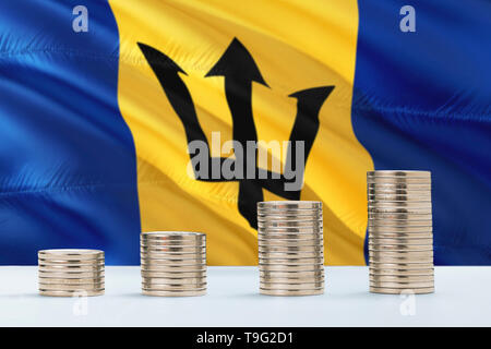 Barbados Flagge schwenkten im Hintergrund mit Reihen von Münzen, die für Finanzen und Business Konzept. Spart Geld. Stockfoto