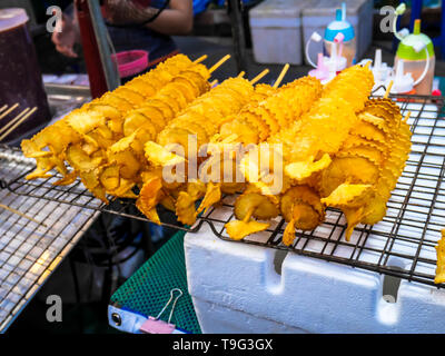 Spirale Kartoffeln gebraten, auf Holzstäbchen, Spirale. Verkauf von Speisen auf dem Markt. Stockfoto