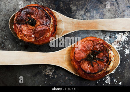 Tomaten mit Reis mit Holzlöffel auf Metallplatte Stockfoto