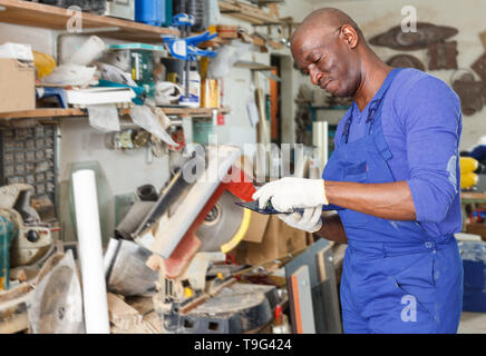 Zuversichtlich African American Glass Factory worker Schneiden von Glas auf der Kreissäge in Werkstatt Stockfoto