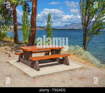 Picknickplatz mit Tisch und Bänken am Ufer des Okanagan See. Stockfoto