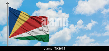 Seychellen Fahne im Wind gegen Weiße bewölkt blauer Himmel. Diplomatie Konzept, internationale Beziehungen. Stockfoto