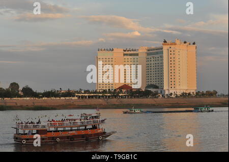 Ein Dinner-Kreuzfahrtschiff. Flussschifffahrt auf dem Tonle SAP River in der Dämmerung, das Sokha Hotel im Hintergrund, Phnom Penh, Kambodscha. Kredit: Kraig lieb Stockfoto