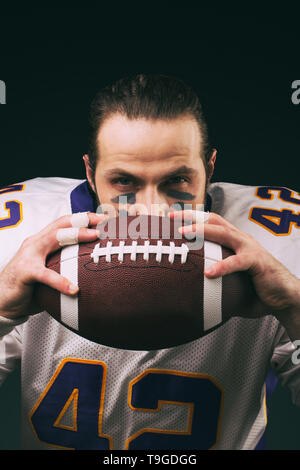 Portrait von American Football Spieler mit einem Ball und Kamera Stockfoto