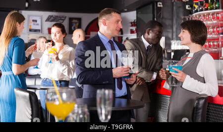 Freundliche Mitarbeiter in angenehmen Gespräch und Flirten im Büro Partei in Nachtclub Stockfoto