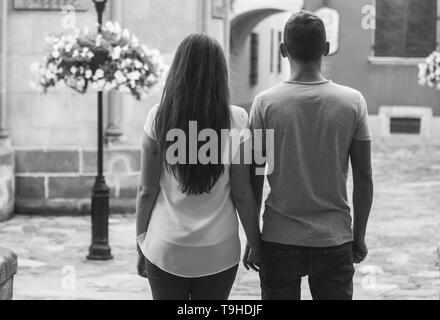 Moody schwarz-weiß Bild von Paar stehend in die leere Straße und halten sich an den Händen. Stockfoto