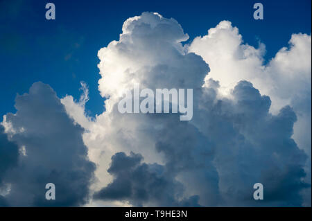 Abstrakte Sicht der wogenden Gewitterwolken Gebäude gegen strahlend blauen Sommerhimmel Stockfoto