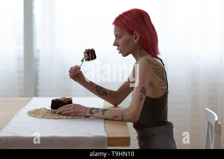 Skinny Frau über die großen Stück süsse Kuchen denken Stockfoto