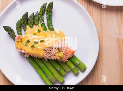 Gedünsteter Spargel mit gebackenen Lachs filet und Sauce Hollandaise auf der Oberseite. Köstlich gesunde Mahlzeit Stockfoto
