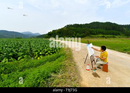 (190519) - Peking, 19. Mai 2019 (Xinhua) - Lin Fusheng arbeitet auf einem Gemälde am Eingang Hualian Dorf Huashan County im Lichuan County, im Osten der chinesischen Provinz Jiangxi, 16. Mai 2019. Lin Fusheng, ein Dorfbewohner aus Hualian Dorf Huashan County im Lichuan County, litt unter körperlicher Behinderung aufgrund von Kinderlähmung. Trotz, dass Lin stecken mit seinem Traum von einem Maler. Wie Lichuan County schnelle Entwicklung der Ölmalerei Industrie in 2013 erlebt, Lin zurück in seine Heimatstadt und wuchs als professioneller Maler mit Hilfe der lokalen Regierung. Jetzt Li Stockfoto