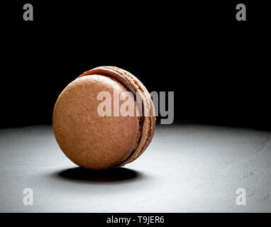 Schokolade Macaron auf dem schwarzen Hintergrund, in der Nähe Stockfoto