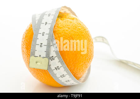 Orange mit weißen Maßband um ihn herum gewickelt. Auf einem weißen Hintergrund. Stockfoto