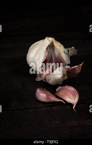 Knoblauch Zwiebel Split mit Losen Nelken auf dunklen Board mit Kopie Raum Stockfoto