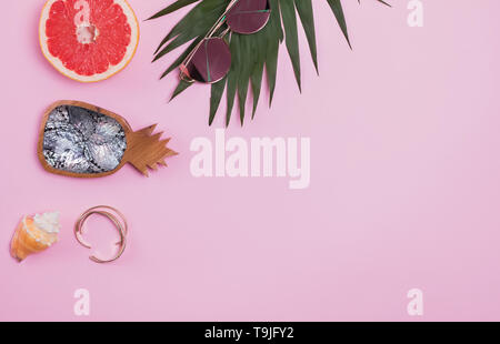 Kreative Sommer Komposition mit Palm Leaf, Grapefruit und Sonnenbrille auf dem rosa Hintergrund Stockfoto