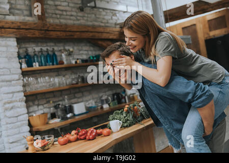 Reizende junge Paar Spaß zusammen mit rustikalen Küche Stockfoto