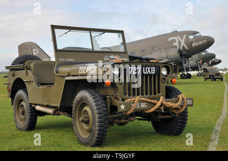 Zweiten Weltkrieg Douglas C-47 Skytrain Flugzeuge im Zeitraum camouflage Markierungen zusammen in Europa zum ersten Mal seit vielen Jahren, mit Willys Jeeps Stockfoto