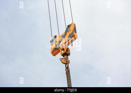 Kran Lasthaken gegen den Himmel mit Wanderwegen und Kette. Stockfoto