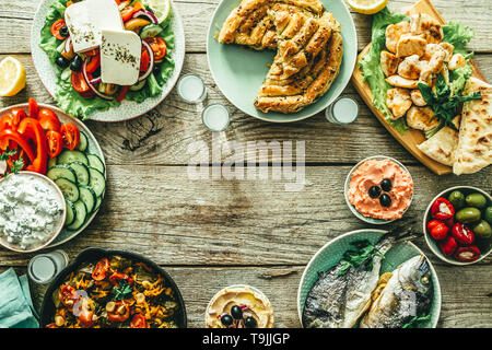 Auswahl an traditionellen griechischen Essen - Salat, Meze, Kuchen, Fisch, Tzatziki, dolma auf Holz Hintergrund Stockfoto