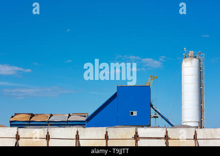 Komponenten für die Produktion von Zement in Behältern gegen den blauen Himmel. Stockfoto