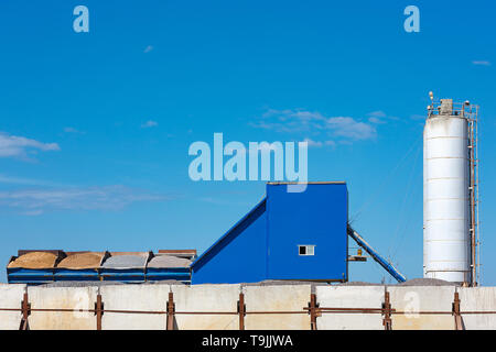 Komponenten für die Produktion von Zement in Behältern gegen den blauen Himmel. Stockfoto