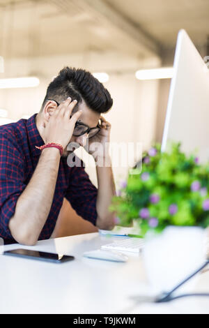 Müde und besorgt, Inder am Arbeitsplatz im Büro Stockfoto