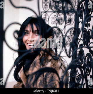 Porträtaufnahme der deutschen Plant und Sängerin Dunja Rajter neben einem Schmuckvollen Eisentor, Deutschland Ca. 1975. Portrait der deutschen Schauspielerin und Sängerin Dunja Rajter neben einem dekorativen Iron Gate, Deutschland Ca. 1975. Stockfoto