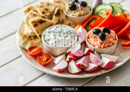 Auswahl an traditionellen griechischen Essen - Salat, Meze, Kuchen, Fisch, Tzatziki, dolma auf Holz Hintergrund Stockfoto