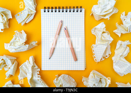 Bleistift und Notizbuch auf gelbem Hintergrund. Zerknittertes Papier. Stockfoto