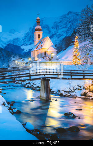 Schöne Dämmerung Blick auf Sankt Sebastian Wallfahrtskirche mit geschmückten Weihnachtsbaum während der Blauen Stunde leuchtet in der Dämmerung im Winter, Ramsau, Nat Stockfoto