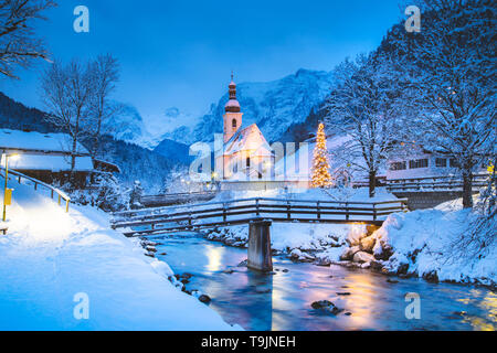 Schöne Dämmerung Blick auf Sankt Sebastian Wallfahrtskirche mit geschmückten Weihnachtsbaum während der Blauen Stunde leuchtet in der Dämmerung im Winter, Ramsau, Nat Stockfoto