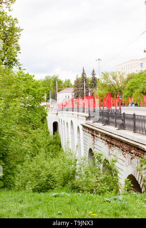 Kaluga, Russland - Mai 11, 2019: Blick auf den Steinbogen Brücke über die Schlucht mit roten Fahnen Berezuysky Stockfoto