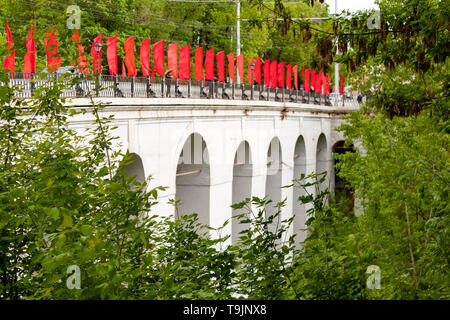 Kaluga, Russland - Mai 11, 2019: Blick auf den Steinbogen Brücke über die Schlucht mit roten Fahnen Berezuysky Stockfoto