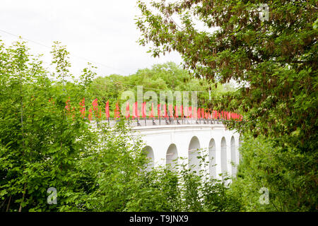 Kaluga, Russland - Mai 11, 2019: Blick auf den Steinbogen Brücke über die Schlucht mit roten Fahnen Berezuysky Stockfoto