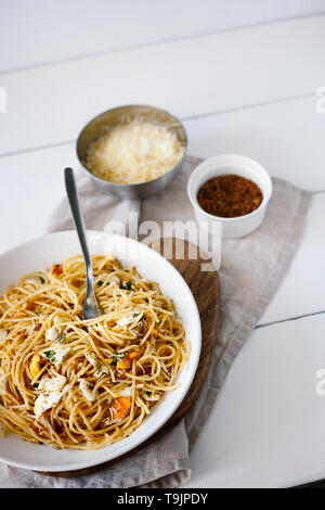 Schnelle und leckere italienische Pasta Spaghetti mit Spiegelei, pangrattato und geriebenem Parmesan auf weiße Platte auf weißem Hintergrund der Ansicht von oben Stockfoto