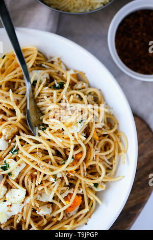 Schnelle und leckere italienische Pasta Spaghetti mit Spiegelei, pangrattato und geriebenem Parmesan auf weiße Platte close-up Top View. Frische hausgemachte Speisen Stockfoto